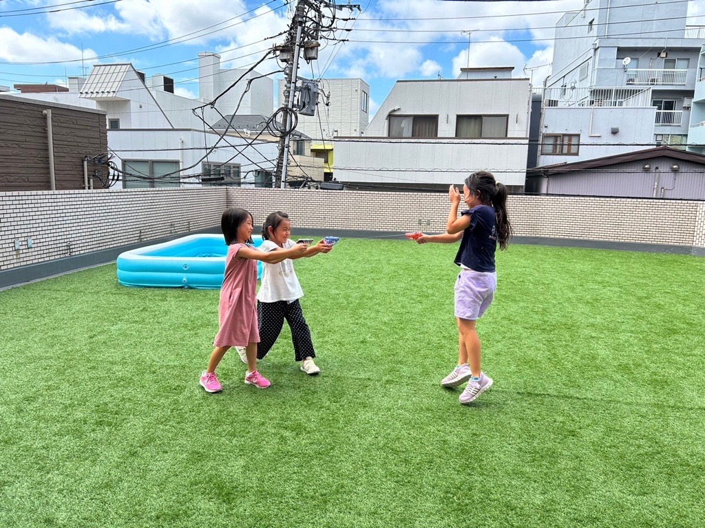 横浜 鶴見 英語学童フレックルズ 人工芝テラスで走る子ども